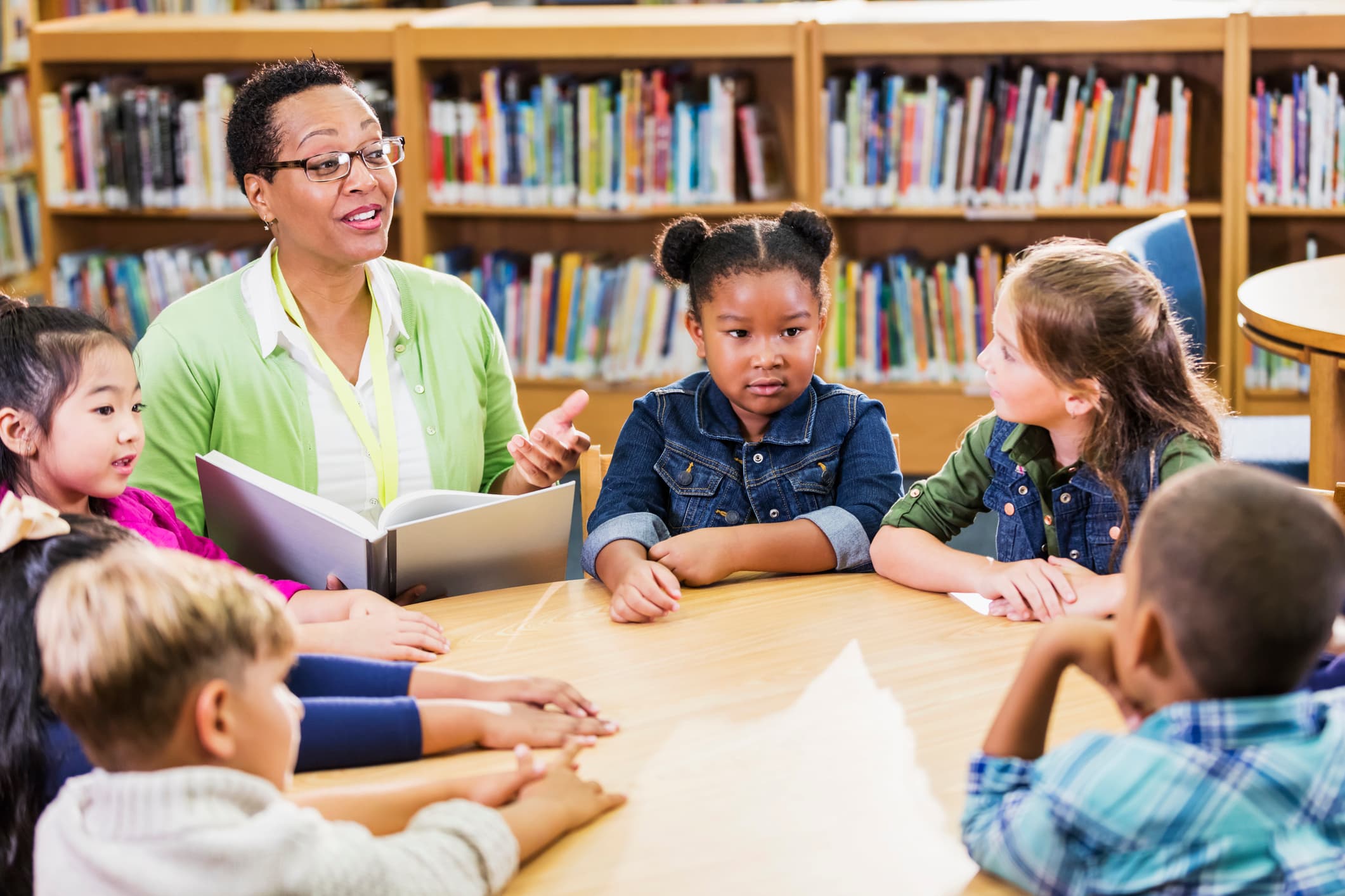 Teacher reading to children in library
