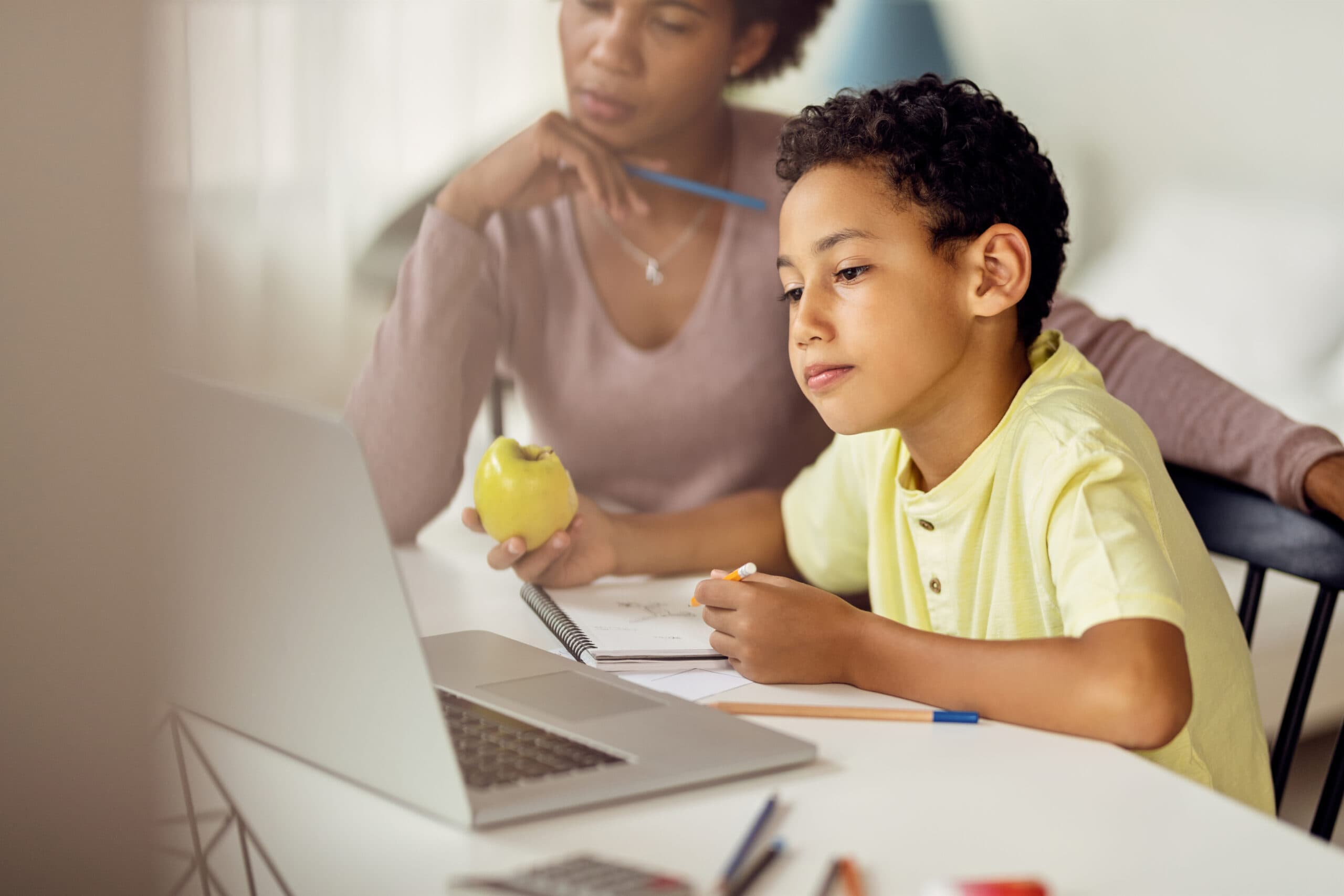 A teacher watching a boy studying
